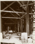 Interior work : barrels, wheelbarrows and a cart beneath wooden scaffolding