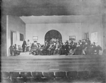 Scene from "An enemy of the people". Setting by Claude Bragdon. Walter Hampden (Dr. Stockmann), extreme left, seated. NYC: Hampden Theatre, 1927. Revival.