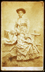 Portrait of unidentified young woman in plaid dress and hat.
