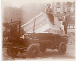 Two men with a block of marble on a cart