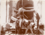 Group of workers tying ropes around a block of marble