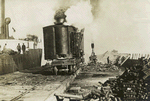Loading pig iron by magnet at the Canadia northern docks at Port Arthur, Ont. The magnet's capacity is two tons each lift.