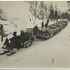 Steam tractor sled pulling logs.