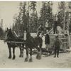 Horse drawn sled carrying a large load.]