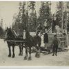 Horse drawn sled carrying a large load.