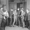 Lee Tracy as Hildy Johnson (being manhandled by the "cops").