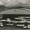 Propeller planes in front of hangar