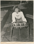 Margaret Sullavan leans on bamboo chair