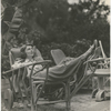 Margaret Sullavan lounging on wicker chair