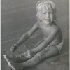 Bridget Hayward dribbling sand on her legs on the beach