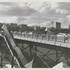 View of pedestrian and traffic overpass connecting West 155th Street to the Macombs Dam Bridge, in Harlem, New York, with the apartment buildings along Edgecombe Avenue visible in the background, ca. late 1940s