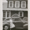 Opera singer Ellabelle Davis posing with a car in front of her home
