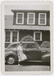 Opera singer Ellabelle Davis posing with a car in front of her home