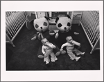 Twin boys with bottles and large stuffed panda bears