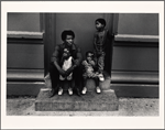 Father and three children sitting on a step