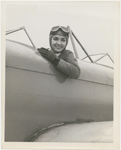  Nana Gollner seated in an open cockpit plane with aviator goggles and cap. 