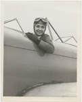 Nana Gollner seated in an open cockpit plane with aviator goggles and cap.