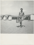 Paul Jacobs on the beach carrying picnic basket