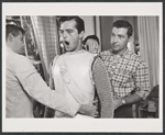 Robert Goulet being fitted for her costume for the stage production Camelot