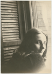 Tanaquil Le Clercq in an informal pose looking over her shoulder with window and shutter in background