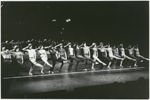 A Chorus Line cast members in line kicking holding hats on their heads