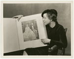Helen Hayes views scrapbook for the stage production Victoria Regina prepared as a gift for Her Majesty Queen Mary