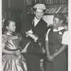 Actress Rosalind Russell, with two students from the St. Charles Parochial School, attending the Second Annual Tea of the St. Charles Women's Auxiliary, held at the Duchesne Residence School, in New York City, in May 1953. Ms. Russell, with three others, received awards for their contributions in the field of Human Relations
