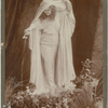 Full-length studio portrait of Loie Fuller holding veil over her head and pouring water from a shell.