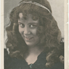 Studio head shot of Loie Fuller with string of pearls in her hair.