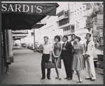 Publicity photo of Ralph Williams, Zohra Lampert, Zack Matalon, Clinton Kimbrough, Collin Wilcox, and Burt Reynolds from the stage production Look, We've Come Through outside of Sardi's restaurant