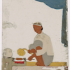 Seated male food vendor roasting meat on spit,  fanning flames