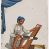 Seated male carpenter sawing a board, with tools on the ground