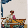 Seated male emroiderer sitting on striped rug