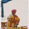 Seated male silversmith/jewelrymaker in front of small jewellry and tools