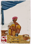 Seated male silversmith/jewelrymaker in front of small jewellry and tools