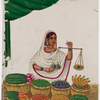 Seated female fruit vendor holding a balance