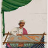 Seated male emroiderer on blue striped rug