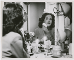 Portrait of actress Hilda Simms in a dressing room applying makeup before a performance, ca. 1940s.