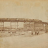 Elevated railroad curve & train; men working on streetcar tracks