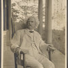 Photograph of SLC on a verandah in wicker rocking chair, smoking. Inscribed and signed, 1906. 