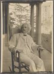 Photograph of SLC on a verandah in wicker rocking chair, smoking. Inscribed and signed, 1906. 