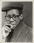 Teenage boy in glasses holding a cigarette