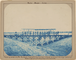 Measuring across one of the Dry sloughts. Trestle 115 feet long. 22 feet high at footpath (the dark part of the bridge. 25 feet at rail shown as the tight part and entirely independent from the other