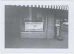 Exterior view of local Student Nonviolent Coordinating Committee headquarters in unidentified location, with sign bearing group's name and SNCC posters displayed in the window, circa early 1960s.