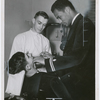 United States Navy dentist Lt. Frank Louis Peterson, Jr. (right) with an unidentified assistant, performing a dental examination