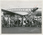 Members of Ballet Theatre grouped in front of an airplane