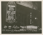 Night photograph of the lighted signs and marquee for the Warner movie theater featuring Ballet Theatre