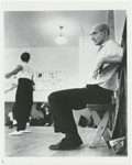 Antony Tudor seated on a small bench watching a rehearsal