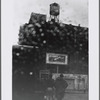 Gas station with N.Y. Giants billboard and watertower in the rain