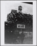Gas station with N.Y. Giants billboard and watertower in the rain
